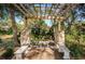 Stone pergola with benches provides a tranquil spot for relaxation at 2180 Clover Hill Rd, Palm Harbor, FL 34683