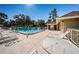 Community pool area with lounge chairs, tables, and a nearby restroom building on a sunny day at 2180 Clover Hill Rd, Palm Harbor, FL 34683