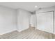 Neutral bedroom with gray laminate flooring, white walls, a built-in closet, and updated lighting at 2530 Sunset Dr, Largo, FL 33770