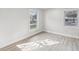 Bright bedroom with two large windows, neutral gray laminate flooring, and fresh white paint at 2530 Sunset Dr, Largo, FL 33770