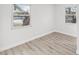 Bright bedroom with two windows, neutral gray laminate flooring, and fresh white paint at 2530 Sunset Dr, Largo, FL 33770