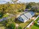 Charming single-story home with a well-maintained lawn and mature tree, surrounded by a white picket fence at 2530 Sunset Dr, Largo, FL 33770