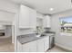 Well-lit kitchen boasts granite countertops, stainless steel dishwasher, and ample cabinet space at 2530 Sunset Dr, Largo, FL 33770
