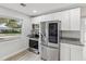 Modern kitchen featuring stainless steel appliances, granite countertops, and white cabinetry at 2530 Sunset Dr, Largo, FL 33770