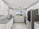 Modern kitchen with stainless steel appliances, granite countertops, and sleek white cabinets at 2530 Sunset Dr, Largo, FL 33770
