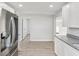 Spacious kitchen with stainless steel refrigerator, granite counters, and stylish gray flooring at 2530 Sunset Dr, Largo, FL 33770