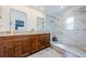 Stylish bathroom with a double vanity, granite countertops, and a modern walk-in shower featuring elegant marble-style tile at 3350 Brian N Rd, Palm Harbor, FL 34685