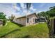 Exterior shot with a fenced backyard leading to a screened lanai and pool at 3350 Brian N Rd, Palm Harbor, FL 34685