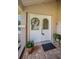 Close-up of the charming front door with floral accents, welcoming guests to the home at 3350 Brian N Rd, Palm Harbor, FL 34685