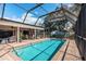 A refreshing swimming pool with a screened enclosure and an adjacent patio and outdoor dining area at 3350 Brian N Rd, Palm Harbor, FL 34685