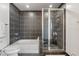Bathroom featuring a shower with glass doors, a bathtub, and dark tile at 400 4Th S Ave # 704, St Petersburg, FL 33701