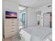 Bedroom featuring a light wood dresser, TV, and balcony with sliding glass doors at 400 4Th S Ave # 704, St Petersburg, FL 33701
