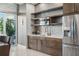 Modern kitchenette featuring sleek cabinetry, stainless steel appliances, and a stylish backsplash, with view to outdoor pool at 400 4Th S Ave # 704, St Petersburg, FL 33701