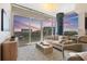 Comfortable living room featuring a beige sofa, accent chairs, stylish rug, and expansive windows with stunning sunset views at 400 4Th S Ave # 704, St Petersburg, FL 33701