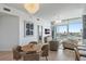 Open-concept living area with dining table, stylish chandelier, and expansive windows overlooking the city at 400 4Th S Ave # 704, St Petersburg, FL 33701