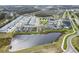 Aerial shot of neighborhood homes nestled around a serene pond and lush landscaping at 4016 Cadence Loop, Land O Lakes, FL 34638