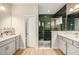 Modern bathroom featuring dual sinks, granite countertops, and glass enclosed shower with stylish green tiling at 4016 Cadence Loop, Land O Lakes, FL 34638