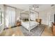 Bright bedroom featuring a four poster bed, hardwood floors, a ceiling fan, and natural light from a window at 4016 Cadence Loop, Land O Lakes, FL 34638