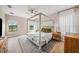 Bright bedroom with a four-poster bed, neutral decor, and views of the outdoors at 4016 Cadence Loop, Land O Lakes, FL 34638