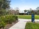 Scenic view of a community park with a sidewalk sign, trees, and a peek of the clubhouse at 4016 Cadence Loop, Land O Lakes, FL 34638