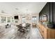 Dining area with a long wooden table, modern light fixture, and views of the outdoor landscape at 4016 Cadence Loop, Land O Lakes, FL 34638