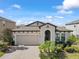 Charming single-Gathering home boasts a manicured lawn, arched entryway, and a two-car garage at 4016 Cadence Loop, Land O Lakes, FL 34638