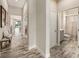 Bright hallway with wood-look tile flooring and views of the living spaces and bathroom at 4016 Cadence Loop, Land O Lakes, FL 34638