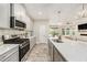 Modern kitchen with stainless steel appliances, white cabinets, and a large island at 4016 Cadence Loop, Land O Lakes, FL 34638