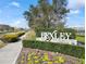 Beautifully landscaped entrance to the Bexley community, showcasing a prominent sign and colorful flowerbeds at 4016 Cadence Loop, Land O Lakes, FL 34638