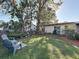 Lush backyard featuring mature trees, potted plants, and outdoor seating, perfect for relaxation and entertaining at 4100 Narvarez S Way, St Petersburg, FL 33712