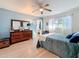 Well-lit bedroom with a modern dresser, light blue walls, and wood laminate flooring at 4100 Narvarez S Way, St Petersburg, FL 33712