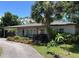 Charming single-story home featuring a lush, landscaped front yard and a welcoming exterior at 4100 Narvarez S Way, St Petersburg, FL 33712