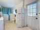 Bright laundry room with appliances, storage, and a folding screen, flooded with natural light at 4100 Narvarez S Way, St Petersburg, FL 33712