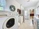 Well-lit laundry room with washer, dryer, and ample storage space, leading into living room at 4100 Narvarez S Way, St Petersburg, FL 33712