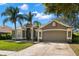 Charming single-Gathering home features a lush lawn, palm trees, and a two-car garage at 434 Knight Dr, Tarpon Springs, FL 34688