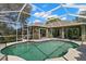 Backyard pool offers privacy and tranquility with its enclosure, palm trees, and inviting blue water at 434 Knight Dr, Tarpon Springs, FL 34688