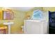 This bathroom features a pedestal sink, large soaking tub and window at 4804 N 10Th St, Tampa, FL 33603
