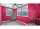 The bedroom features windows, an antique dresser, red walls, and a ceiling fan at 4804 N 10Th St, Tampa, FL 33603