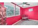 The bedroom features windows, an antique dresser, red walls, and a ceiling fan at 4804 N 10Th St, Tampa, FL 33603