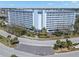 Beautiful ten-story condo building featuring a pool, lush landscaping, and waterfront views at 4939 Floramar Ter # 208, New Port Richey, FL 34652