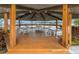 Interior of the waterfront gazebo featuring multiple tables, chairs, and wood flooring at 4939 Floramar Ter # 208, New Port Richey, FL 34652