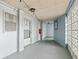 Well-lit outdoor hallway with a white door, concrete floors and a decorative concrete block wall at 4939 Floramar Ter # 208, New Port Richey, FL 34652