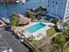 Aerial view of the pool with lounge chairs and surrounding landscaping near the waterway and parking area at 4939 Floramar Ter # 208, New Port Richey, FL 34652
