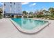 Large outdoor swimming pool with lounge chairs and nearby building at 4939 Floramar Ter # 208, New Port Richey, FL 34652