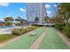 Shuffleboard courts and pool area with the condo in the background at 4939 Floramar Ter # 208, New Port Richey, FL 34652