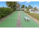 Shuffleboard court with lush landscaping and seating, perfect for outdoor recreation at 4939 Floramar Ter # 208, New Port Richey, FL 34652