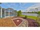 Beautifully landscaped backyard with decorative stone, leading to a screened enclosure with tranquil lake views at 5124 Clover Mist Dr, Apollo Beach, FL 33572