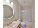 Bathroom with tiled floor, oval mirror, shower with sliding glass door, and wooden sink cabinet at 5124 Clover Mist Dr, Apollo Beach, FL 33572