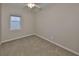 This bedroom features neutral walls, carpet flooring, a window for natural light, and a ceiling fan at 5124 Clover Mist Dr, Apollo Beach, FL 33572