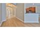 Bright entryway with hardwood floors that flow into the kitchen with stainless steel appliances and granite countertops at 5124 Clover Mist Dr, Apollo Beach, FL 33572